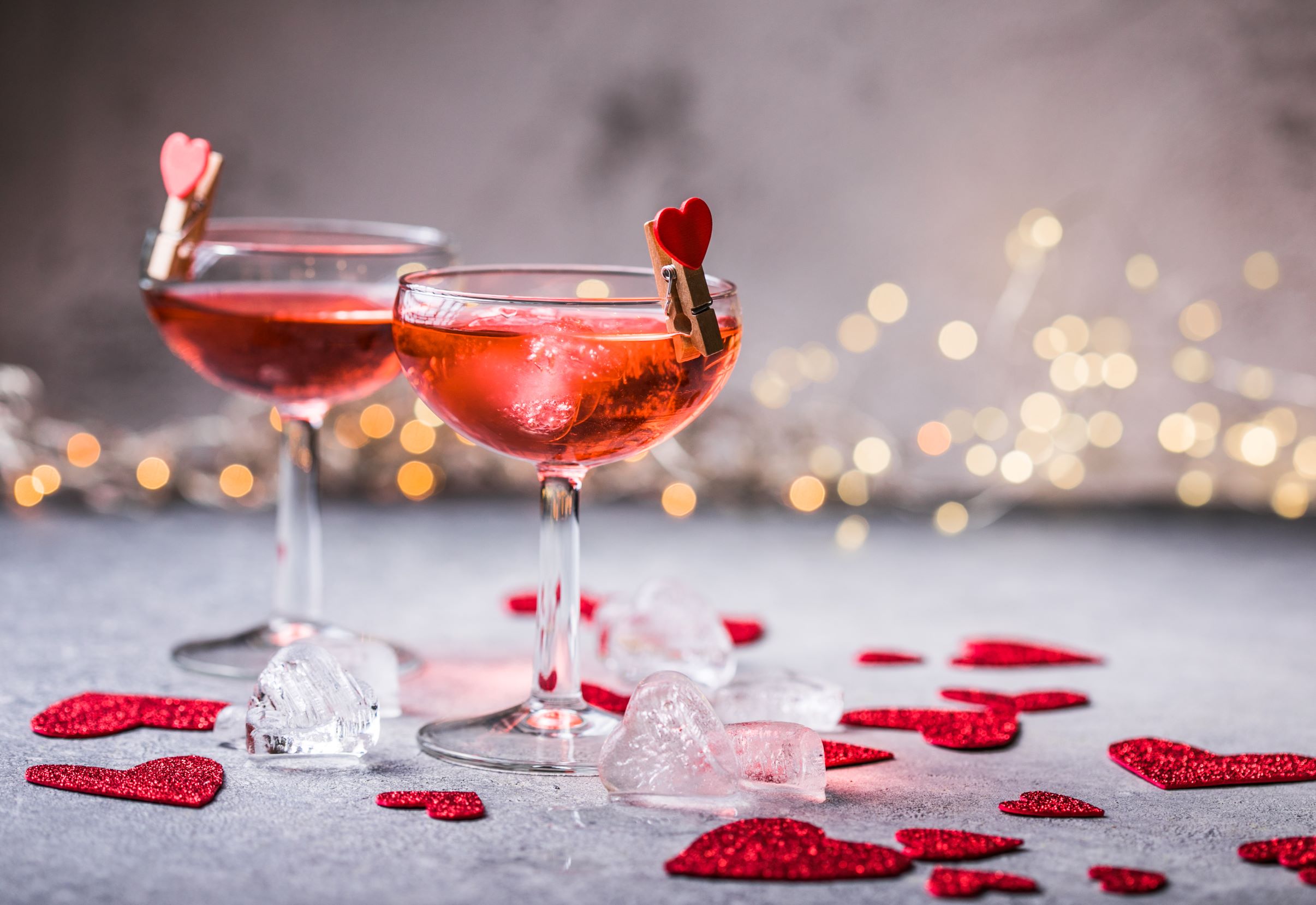 Valentine's Day cocktails surrounded by heart cutouts.